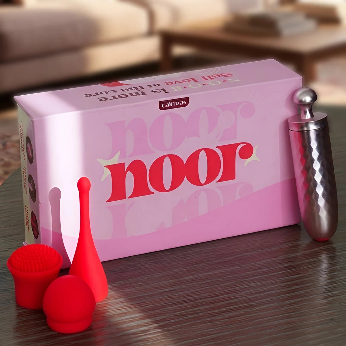 Noor massager with silicone head attachments on wooden surface